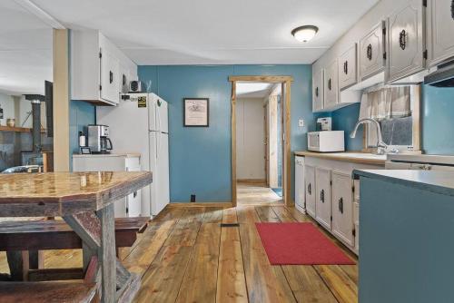 a kitchen with blue walls and a wooden floor at Blue Pine Retreat in Lead
