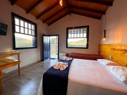 a bedroom with a large bed with two towels on it at Estância do Biribiri in Diamantina