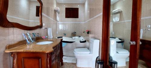 a bathroom with a sink and a toilet at Hotel Residencial Ramire-Tour in Benguela