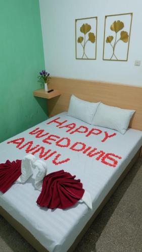 ein Bett mit einem glücklichen Neujahr darauf geschrieben in der Unterkunft The Sri Rejeki Hotel in Blitar