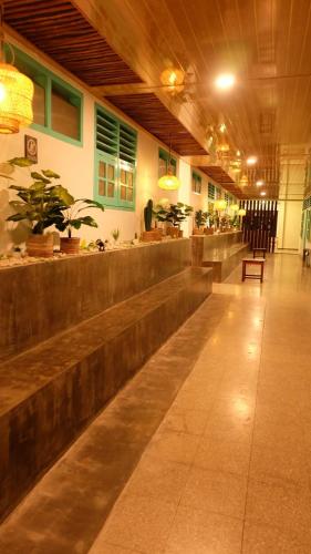 eine Lobby eines Restaurants mit einer Bar mit Pflanzen in der Unterkunft The Sri Rejeki Hotel in Blitar