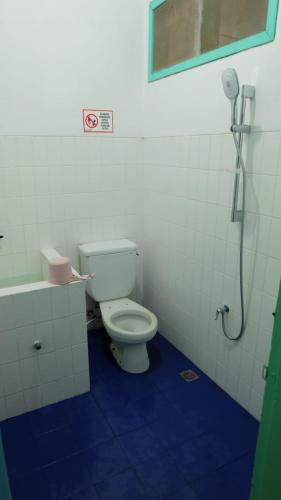ein Bad mit einem WC und einer Dusche in der Unterkunft The Sri Rejeki Hotel in Blitar