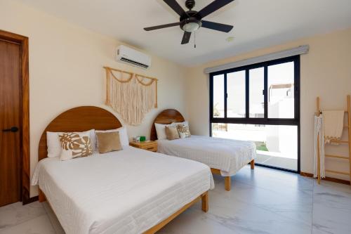 een slaapkamer met 2 bedden en een plafondventilator bij Casa 4 recamaras, alberca, terraza y club playa. in Cruz de Huanacaxtle
