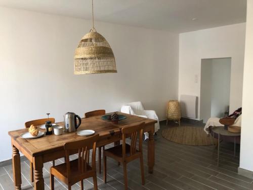 une salle à manger avec une table et des chaises en bois dans l'établissement Appartement catalan coeur village-intégralement rénové, à Argelès-sur-Mer