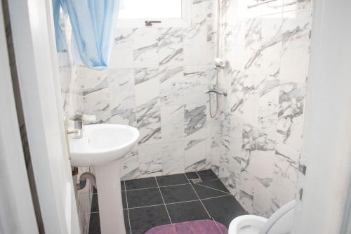 bagno bianco con lavandino e servizi igienici di Studio moderne avec Balcon a Pointe-Noire