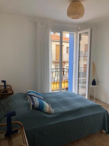 1 dormitorio con 1 cama grande y ventana en Appartement catalan coeur village, en Argelès-sur-Mer