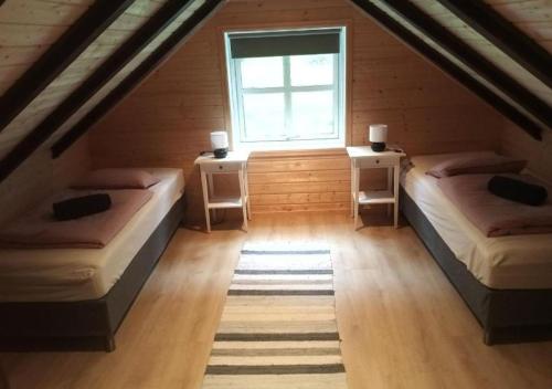 een zolderkamer met 2 bedden en een raam bij An authentic experience in picturesque Eidfjord in Eidfjord