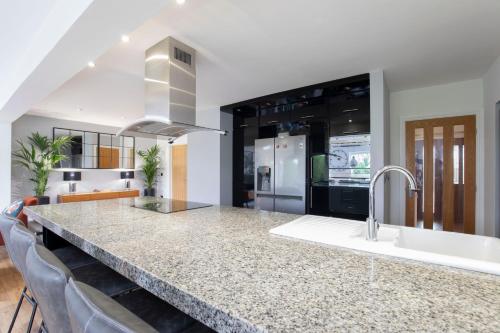 a kitchen with a counter with a sink and a stove at Stunning 3 Bed 2 Bath Detached Village Home in Cheltenham