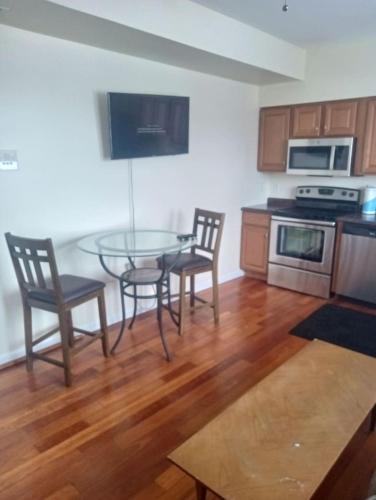 a kitchen with a glass table and chairs in it at godlyone bedroom free parking in Schenectady