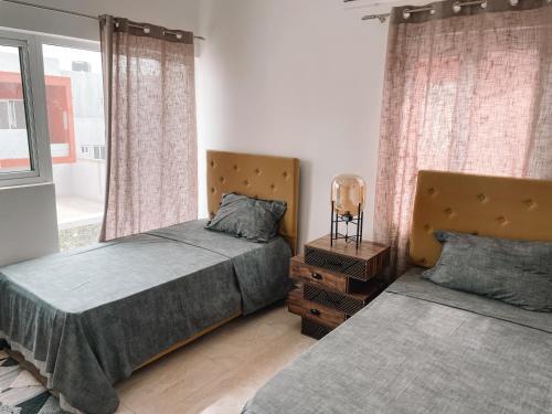 a bedroom with two beds and a window at 3BR house in Tema 25 in Tema