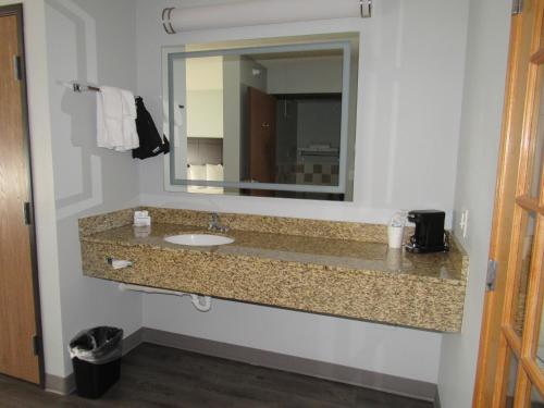 a bathroom with a sink and a mirror at AmericInn by Wyndham Lincoln South in Lincoln