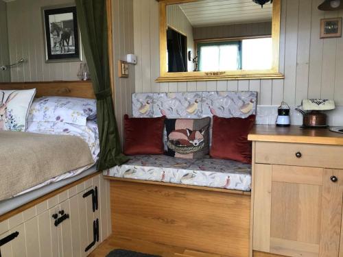 a room with a couch with pillows on it at Shepherd’s Hut with complete privacy in Bottesford