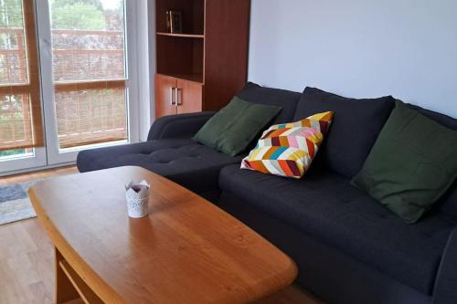 Sala de estar con sofá azul y mesa de centro en Zöld Orom Apartman Lakás, en Göd