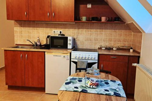 cocina con nevera blanca y mesa en Zöld Orom Apartman Lakás, en Göd