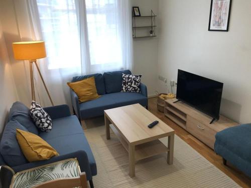 a living room with a blue couch and a tv at May Disc - Long Stay - Contractors in Bristol