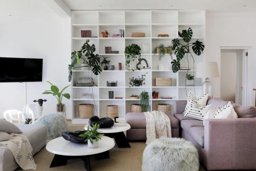 a living room with a couch and tables with plants at Beach House - Number 49 in Cape Town