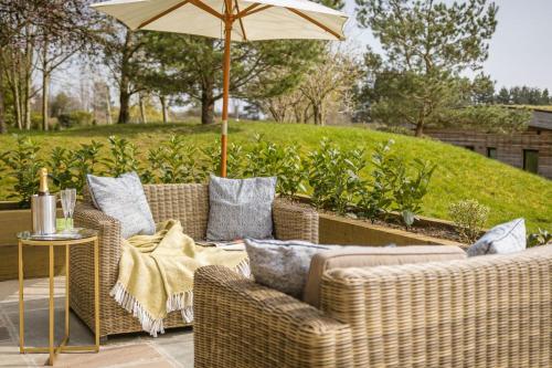 a patio with two wicker chairs and an umbrella at Percy in Richmond