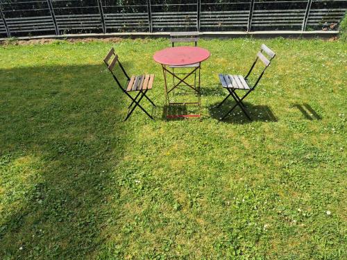 dos sillas y una mesa en el césped en Vélodrome Montigny 2024, en Montigny-le-Bretonneux