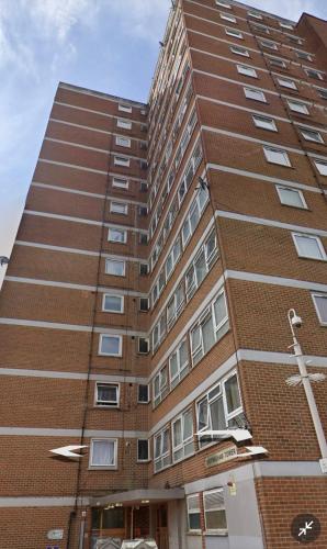 a tall brick building with windows on the side at Sheringham Tower in Southall
