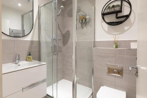 a bathroom with a shower and a sink and a mirror at Stunning two bedroom in city centre in Southampton