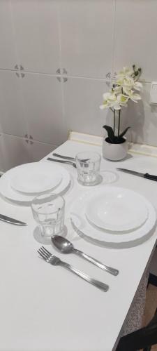 una mesa blanca con platos y cubiertos en Estudio Petrer, en Petrer
