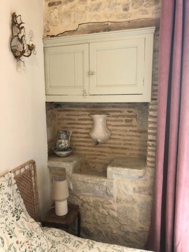 una camera da letto con un muro in pietra con un mobile bianco di Maison St. Clair a Monflanquin