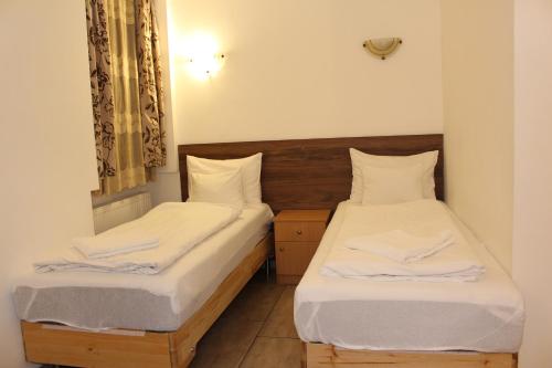 two beds in a small room with white sheets at Esprit Hotel in Budapest