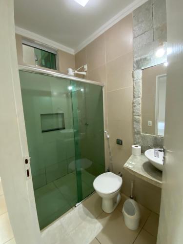 uma casa de banho com um chuveiro, um WC e um lavatório. em Pousada Aliany Lôbo em Pirenópolis
