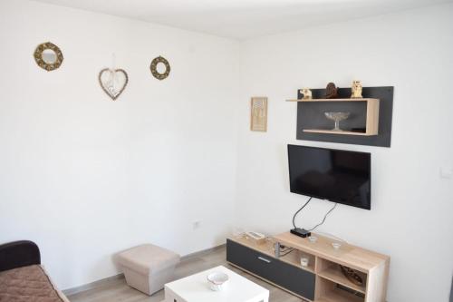 a living room with a tv on a white wall at Milica Apartments in Sutomore