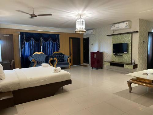 a large room with a bed and a tv at Hotel RNR The Luxury Suits Lodging & Restaurant in Rāichūr