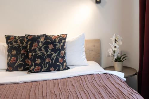 a bed with a black and white pillow on it at Penzion Terasa Cibulka in Mikulov