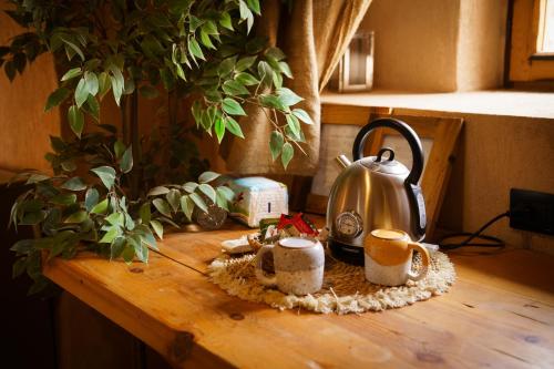 einen Holztisch mit einem Wasserkocher darauf in der Unterkunft Tzila Lodge in Al-Fayyūm