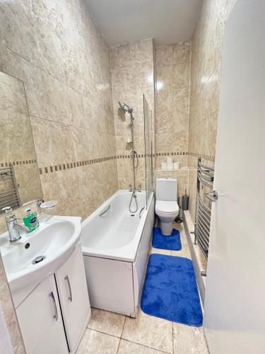 a bathroom with a tub and a toilet and a sink at 2 Bedroom & Living Room Apartment In Paddington in London