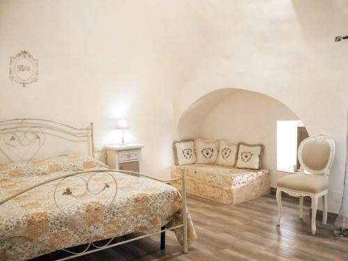 a bedroom with two beds and a chair at Masseria trulli pietra antica in Noci