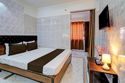 a bedroom with a large bed and a television at OYO Hotel Golden Pride in Shamshabad