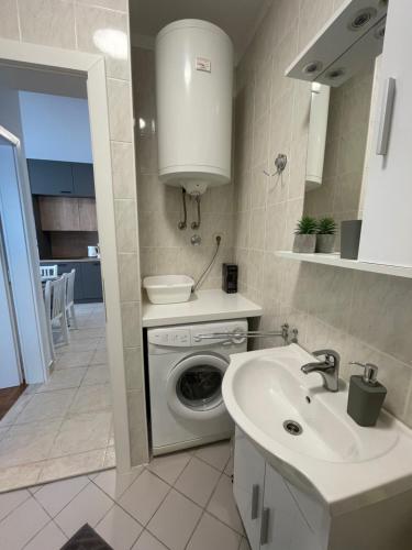 a kitchen with a washing machine and a sink at Apartman Loren in Privlaka