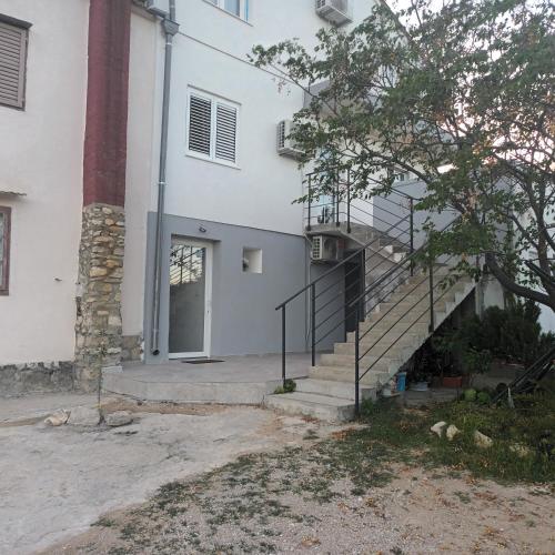 a white building with stairs and a door at Apartman Skradin (nono) in Skradin
