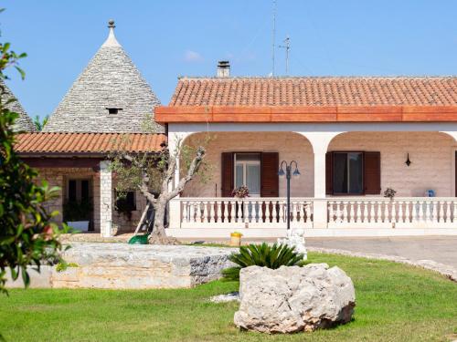 a large house with a large rock in front of it at Masseria trulli pietra antica in Noci