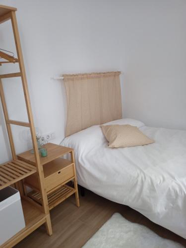 um quarto com uma cama e uma escada ao lado de uma mesa em La Casa de Ángela em Sevilha