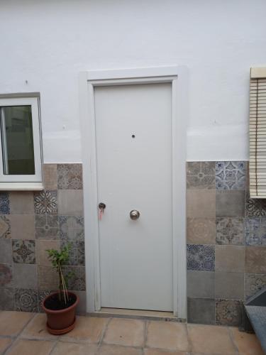 Una puerta blanca en una habitación con una planta en La Casa de Ángela, en Sevilla