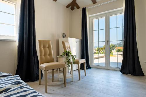 a bedroom with a bed and a table and chairs at Villa Mirage with Private Heated Pool in Orebić
