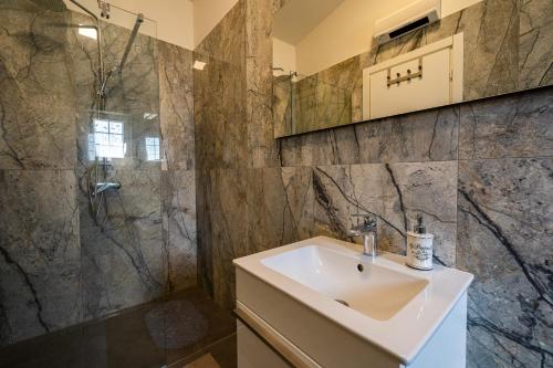 a bathroom with a sink and a shower at Villa Mirage with Private Heated Pool in Orebić