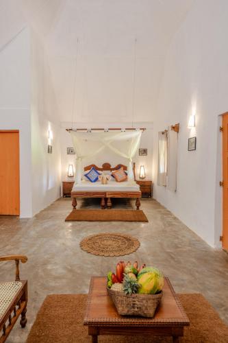 a bedroom with a bed and a bowl of fruit on a table at Amuna Ayurveda and Wellness Retreat in Sigiriya
