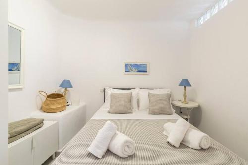 due letti in una stanza con pareti e cuscini bianchi di Sea and Sun beach house at Platis Gialos a Platis Yalos