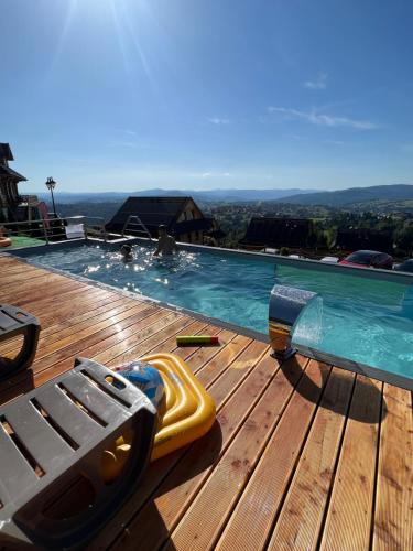 a swimming pool with a toy gun on a wooden deck at Osada Na Ochodzitej in Koniaków