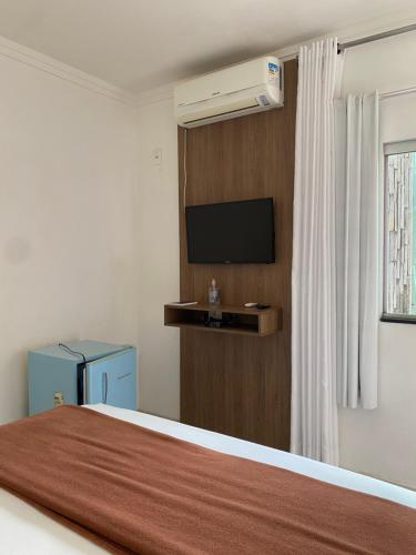 a hotel room with a bed and a television at Pousada Aliany Lôbo in Pirenópolis