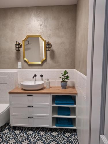 ein Badezimmer mit Waschbecken und Spiegel in der Unterkunft SEA Apartment in Malbork
