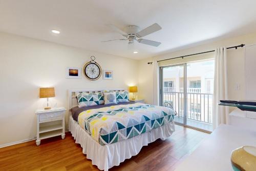a bedroom with a bed with a clock on the wall at The Palm Bay Club Unit 311 in Siesta Key