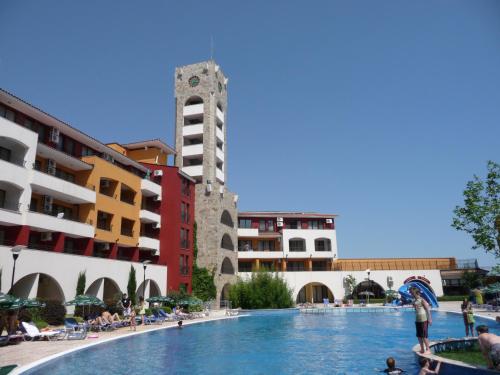 a swimming pool with a clock tower in the background at Relaks w Marina Cape 88 in Aheloy