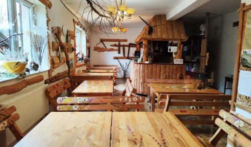 un restaurante con mesas de madera y bancos en una habitación en Hnatowe Berdo BB, en Wetlina